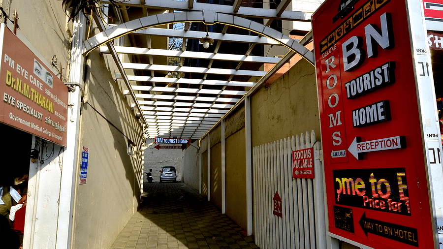 The entrance to BN Tourist Home, with a distinctive red sign and a covered walkway.